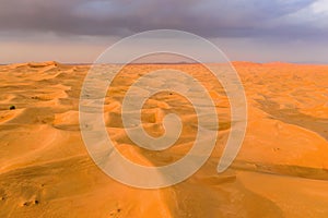 Aerial view of red Desert Safari with sand dune in Dubai City, United Arab Emirates or UAE. Natural landscape background at sunset