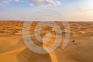 Aerial view of red Desert Safari with sand dune in Dubai City, United Arab Emirates or UAE. Natural landscape background at sunset