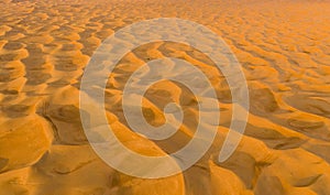 Aerial view of red Desert Safari with sand dune in Dubai City, United Arab Emirates or UAE. Natural landscape background at sunset