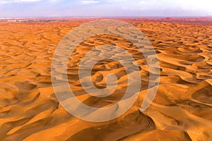 Aerial view of red Desert Safari with sand dune in Dubai City, United Arab Emirates or UAE. Natural landscape background at sunset