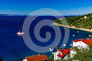 Aerial view of red fishing boat on a deep blue sea in Greece.