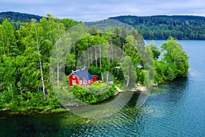 Aerial view of the red house in the forest by the lake