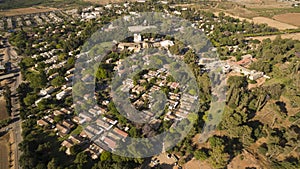 Aerial view of red houses rooftops with green grass and trees in the suburb