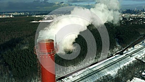 Aerial view of a red industrial smokestack in winter