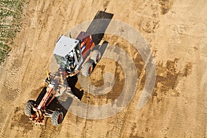 Aerial View of Red Tractor Tilling Dry Soil in Rural Kentucky