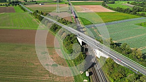 Aerial view of regional train of public transport passing an bridge with cars