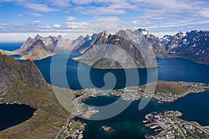 Aerial view of Reine, Lofoten islands, Norway. The fishing village of Reine. Spring time in Nordland. Blue sky. View from above