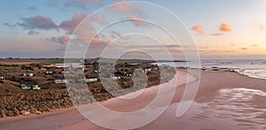 Aerial view of remote beach huts on the Northumberland coast at Embleton Bay