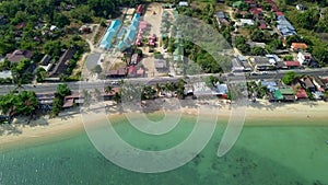 Aerial View of Residental Area with Accommodation and Transport Moving along Road near White Sandy Beach and Sea Shore