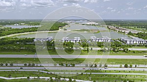 Aerial view of residential apartment buildings near busy american highway with heavy fast moving traffic. Interstate