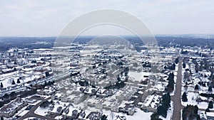 Aerial view of residential houses covered first snow. American neighborhood, suburb. Real estate, drone shots, day time, winter,