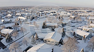 Aerial view of residential houses covered snow at winter season. Establishing shot of american neighborhood, suburb.  Real estate