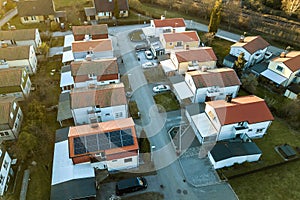 Aerial view of residential houses with red roofs and streets with parked cars in rural town area. Quiet suburbs of a modern