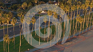 Aerial view of Residential houses and traffic, palm trees in city Santa Barbara, skyline and beach at the sunset