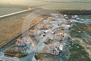 Aerial view of residential houses under construction in rural suburban area. Real estate development