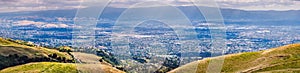 Aerial view of residential neighborhoods of San Jose; golden hills visible in the foreground; south San Francisco bay area,