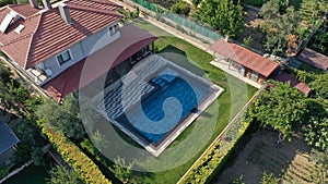 Aerial view of a residential property featuring a large swimming pool in the center of the property