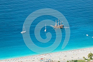 Aerial view of resort beach and tourist ships and yachts in the blue sea lagoon. Vacation and coast in Turkey