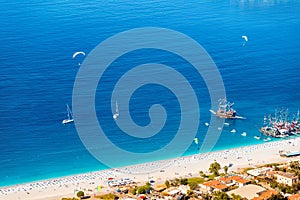 Aerial view of resort beach and tourist ships and yachts in the blue sea lagoon. Vacation and coast in Turkey