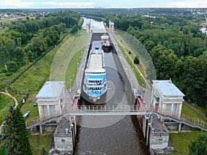 Aerial view river cruise ship passes through locks on the river channel. Tourist routes on river cruises.