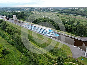 Aerial view river cruise ship passes through locks on the river channel. Tourist routes on river cruises.