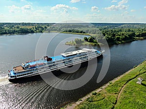 Aerial view river cruise ship sails along the river surrounded by beautiful green forest in summer on a sunny day Cruise Ship Trip