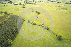 Aerial view of river and empty green meadow field