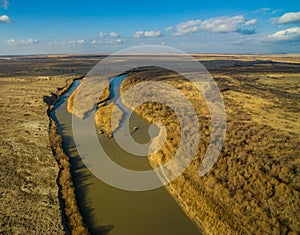 Aerial view of river flowing through forest in alpine valley in Kazakhstan