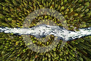 An aerial view of river rapids flowing through lush Finnish taiga forest