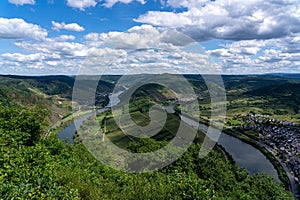 Aerial view of river surrounded by buildings and greenery fields in Moselschleife