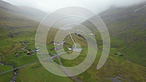 Aerial view of rivers and green hills in Saksun, Faroe Islands on a foggy day
