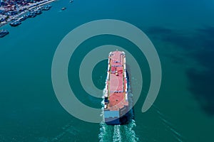 Aerial view ro-ro ship loading new cars. Automotive container carriers sailing on the sea