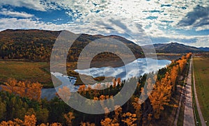 Aerial view of road in beautiful autumn Altai forest