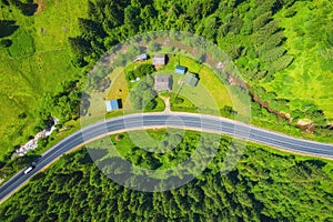 Aerial view of road in beautiful green forest at sunset