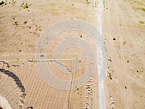 Aerial view of road with car. Aerial view of a country road with sand. Car passing by. Aerial construction road. Aerial view flyin