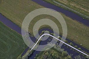 Aerial view of road curving through peat excavation meadow landscape in the netherlands