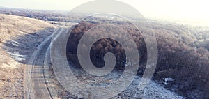 Aerial view on road and forest landscape in winter season.