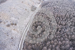 Aerial view on road and forest landscape in winter season.