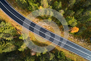 Aerial view of the road in forest. Top view of asphalt roadway