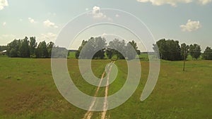 Aerial view of road in green red field, sunny day