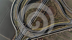 Aerial view of road interchange or highway intersection with busy urban traffic speeding on the road.