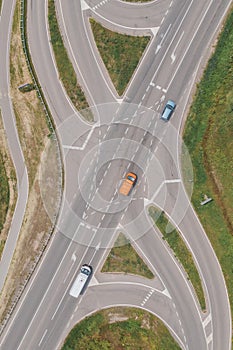 Aerial view of road intersection with car, min van and small bus from drone pov