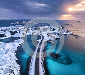 Aerial view of road, island in snow, rorbu, sea, bridge