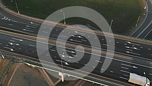 Aerial view of road junction with moving cars. Road interchange. Traffic of expressways, motorways and highways