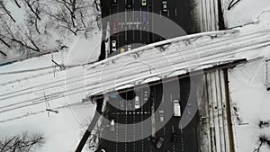 Aerial view of road junction winter time with cars, busses, and other traffic with railway bridge above road.