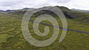 Aerial view of road through mossy lava field in Iceland.