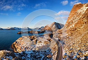 Aerial view at the road in mountains. Mountains and ocean shore during sunset in the Norway.