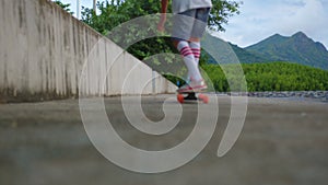 Aerial view of the road with palm trees. Boy riding a skateboard on a beautiful road. Teenager skateboarding on city