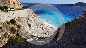 Aerial view from road of people crowd relaxing on beach. Swimming people in sea. Top view of Kaputas Beach between Kas