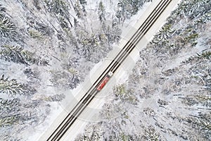 Aerial view of road with red truck in winter forest